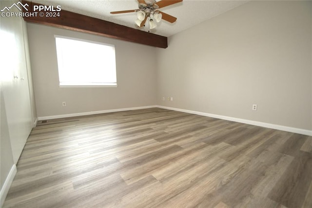 unfurnished room with light hardwood / wood-style floors, a textured ceiling, beam ceiling, and ceiling fan