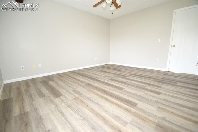 empty room with a textured ceiling, light hardwood / wood-style floors, and ceiling fan