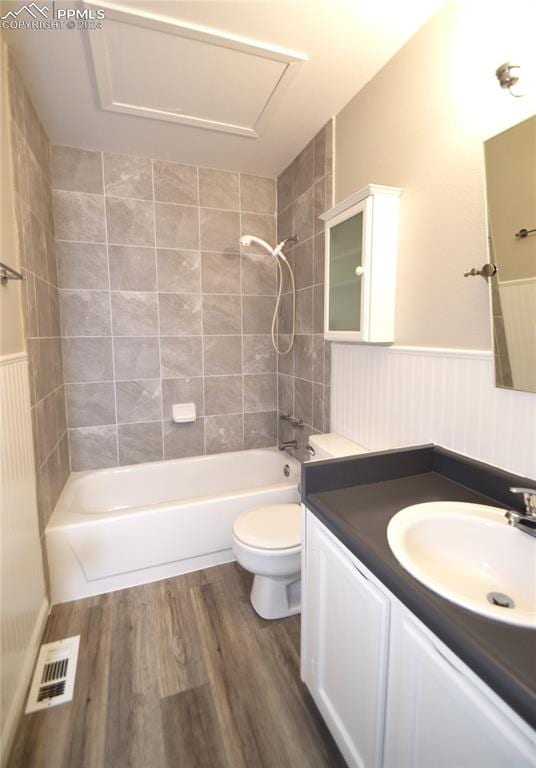 full bathroom with vanity, toilet, hardwood / wood-style flooring, and tiled shower / bath combo