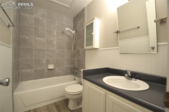 full bathroom featuring vanity, tiled shower / bath combo, wood-type flooring, and toilet