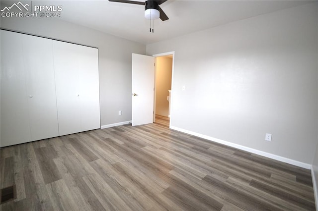 unfurnished bedroom with hardwood / wood-style flooring, a closet, and ceiling fan