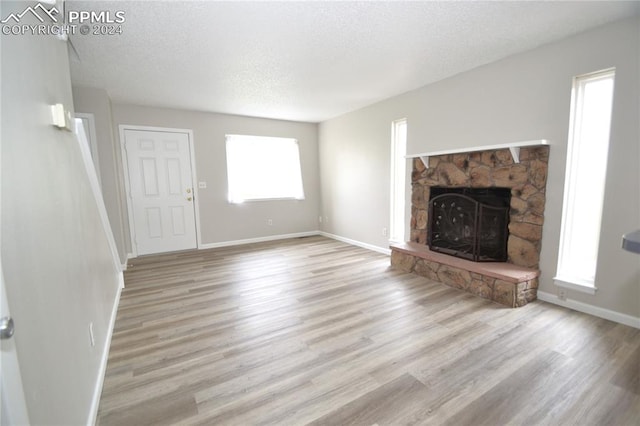 unfurnished living room with a wealth of natural light, light wood-type flooring, and a fireplace