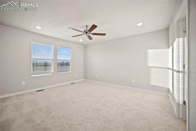 carpeted empty room featuring ceiling fan