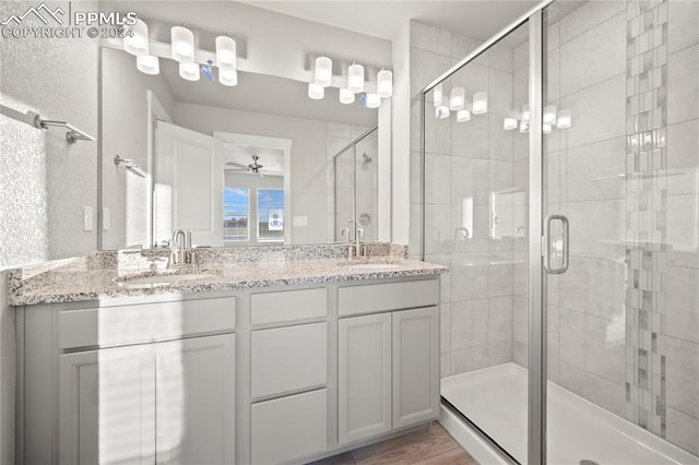 bathroom featuring ceiling fan, vanity, wood-type flooring, and an enclosed shower