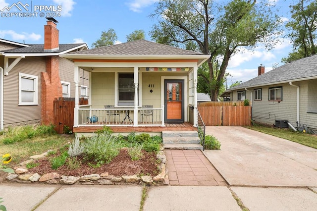 bungalow-style house featuring central air condition unit and covered porch