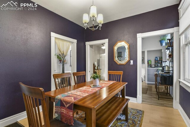 dining space featuring light hardwood / wood-style flooring and a chandelier