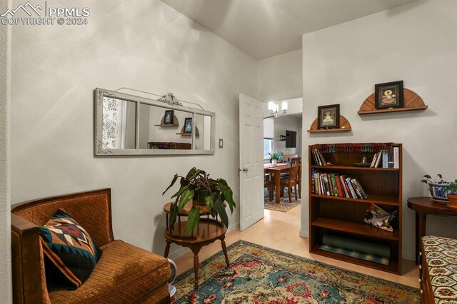 sitting room with light hardwood / wood-style floors and an inviting chandelier