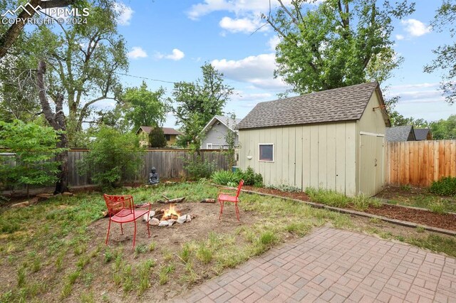 view of yard with a patio, a shed, and a fire pit