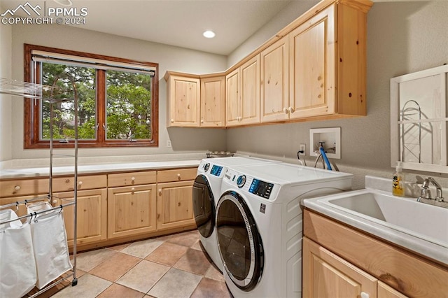 washroom with sink, separate washer and dryer, cabinets, and light tile patterned floors