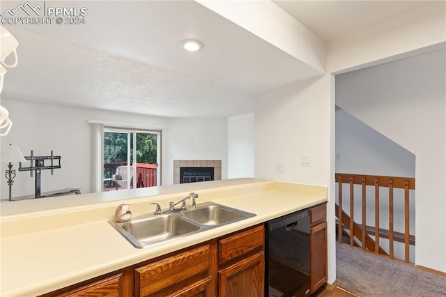 kitchen with light colored carpet, dishwasher, sink, and a tile fireplace