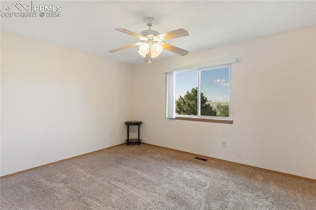 carpeted spare room featuring ceiling fan