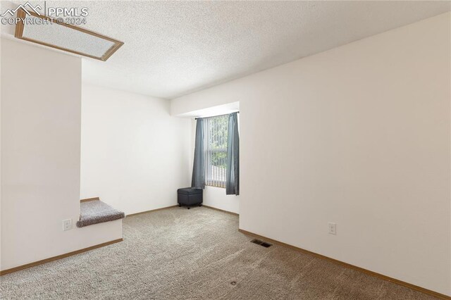 empty room with carpet flooring and a textured ceiling