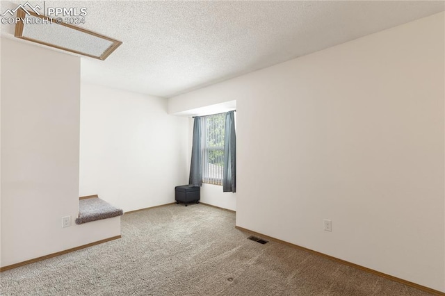 carpeted spare room featuring a textured ceiling