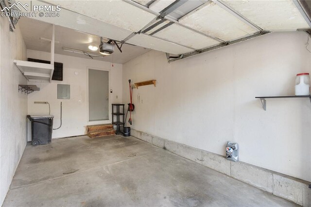 garage with a garage door opener and electric panel