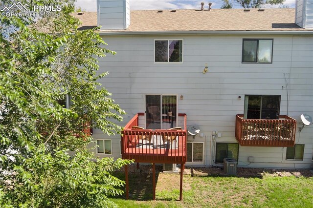 rear view of property with a deck and a lawn