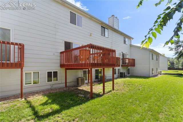 back of property featuring a wooden deck, central AC unit, and a lawn