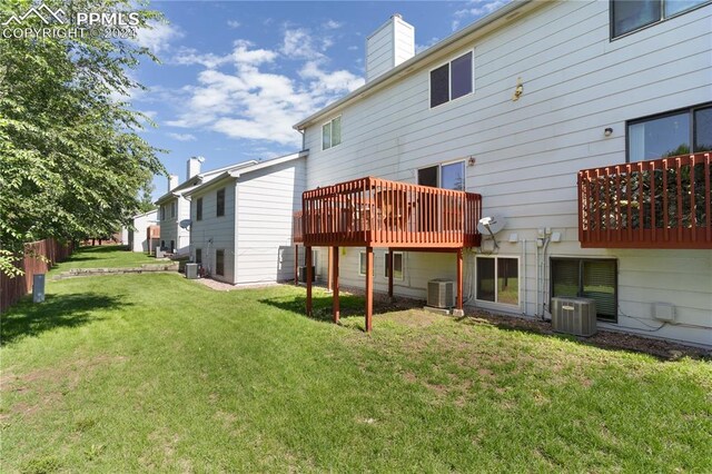 rear view of property with a lawn and central air condition unit