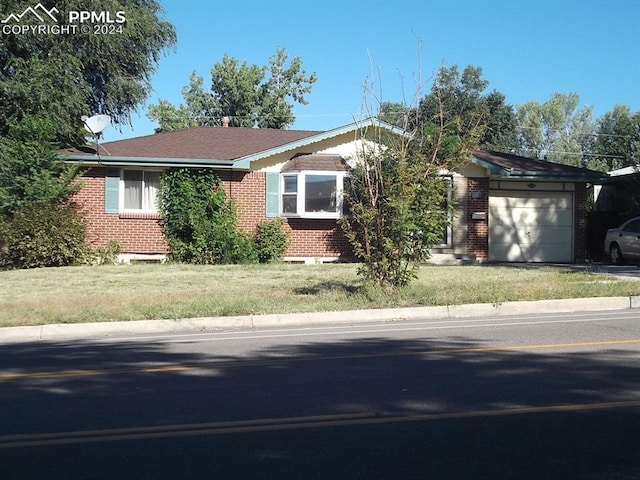 ranch-style home with a garage and a front lawn