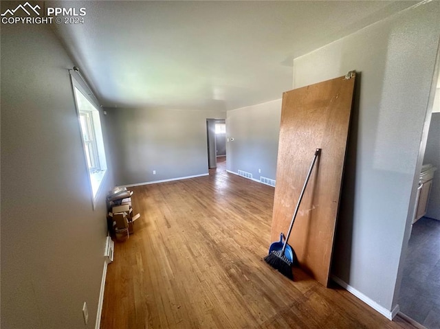 hallway with hardwood / wood-style flooring