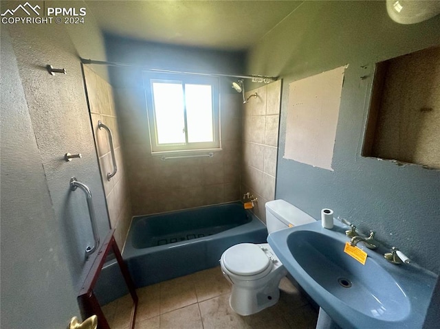 full bathroom featuring sink, tile patterned flooring, tiled shower / bath combo, and toilet