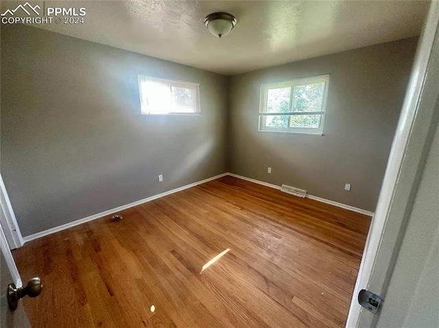 unfurnished room featuring hardwood / wood-style flooring