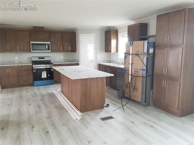 kitchen with sink, stainless steel appliances, and light hardwood / wood-style flooring