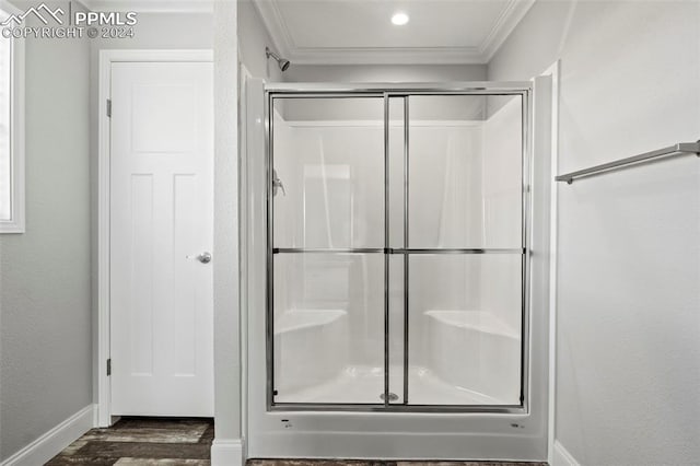 bathroom featuring wood-type flooring, an enclosed shower, and ornamental molding