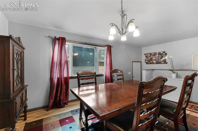 dining space with light wood-type flooring and an inviting chandelier