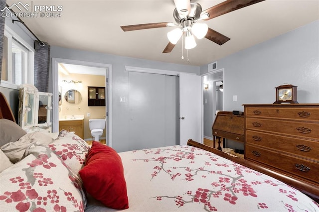 bedroom featuring ceiling fan, ensuite bath, and a closet