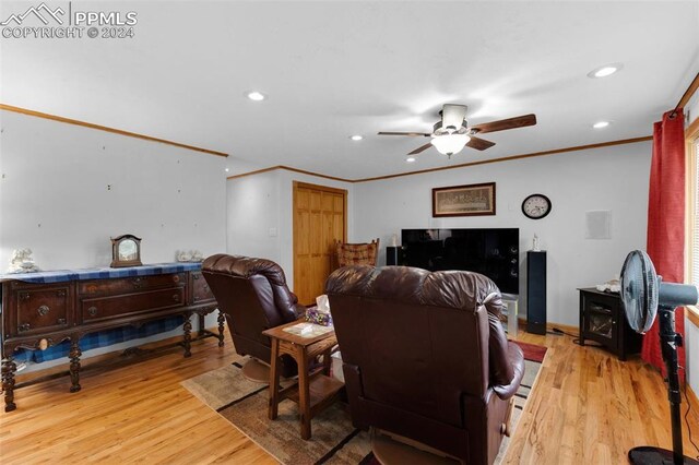 living room featuring ceiling fan, light hardwood / wood-style flooring, and ornamental molding