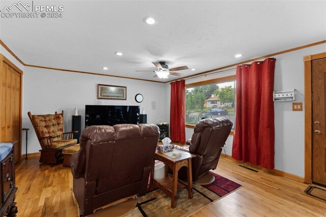 living room featuring ceiling fan, ornamental molding, and light hardwood / wood-style floors