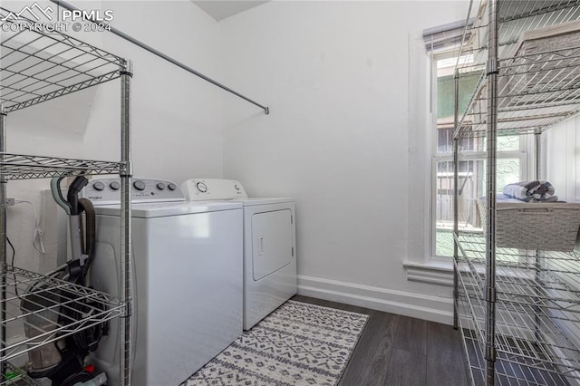 clothes washing area with washing machine and clothes dryer and wood-type flooring