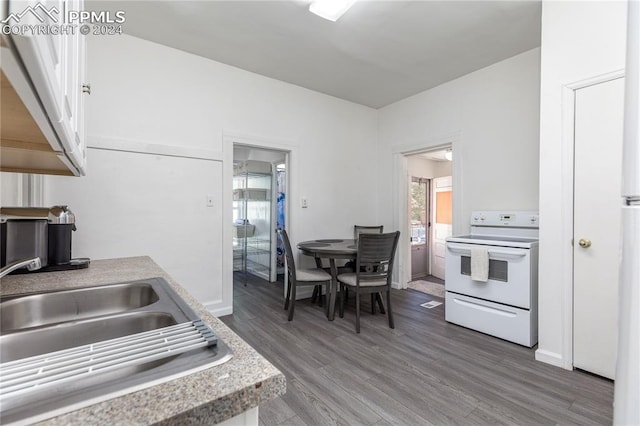 kitchen featuring hardwood / wood-style floors, sink, electric range, and white cabinets