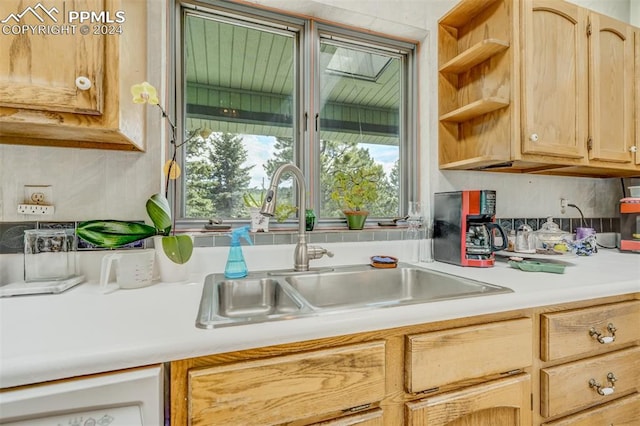 kitchen with light brown cabinets, dishwasher, and sink