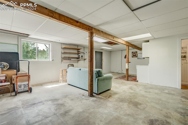 basement with a paneled ceiling and washing machine and clothes dryer