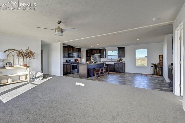 living room featuring ceiling fan, dark wood-type flooring, and sink