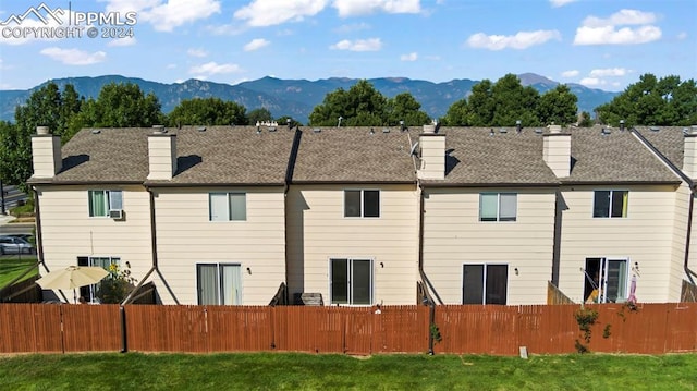 back of property featuring a lawn and a mountain view