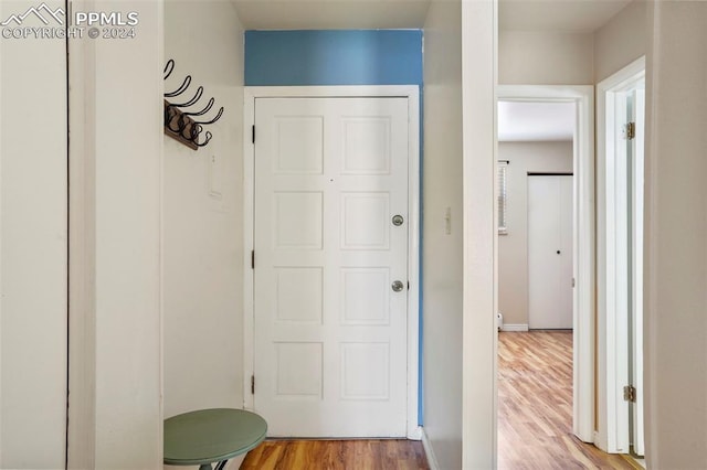 hallway with wood finished floors and baseboards