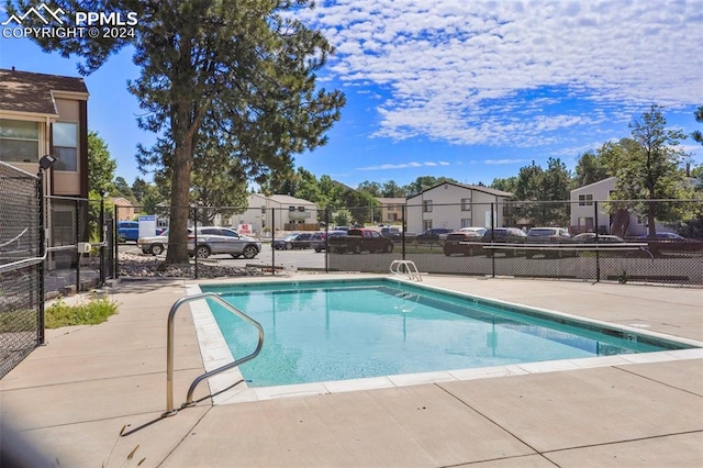 community pool with fence and a residential view