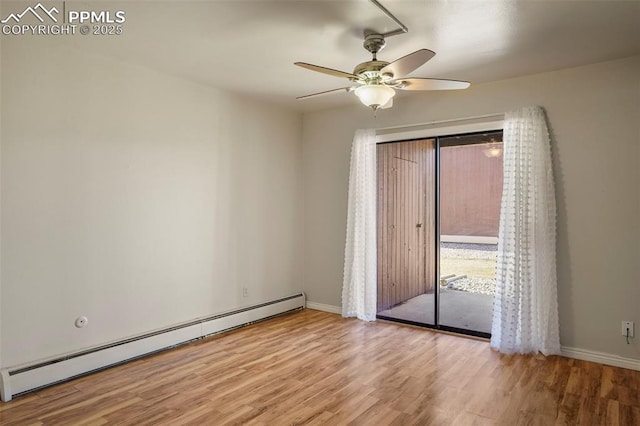 spare room featuring a baseboard heating unit, light wood finished floors, and baseboards