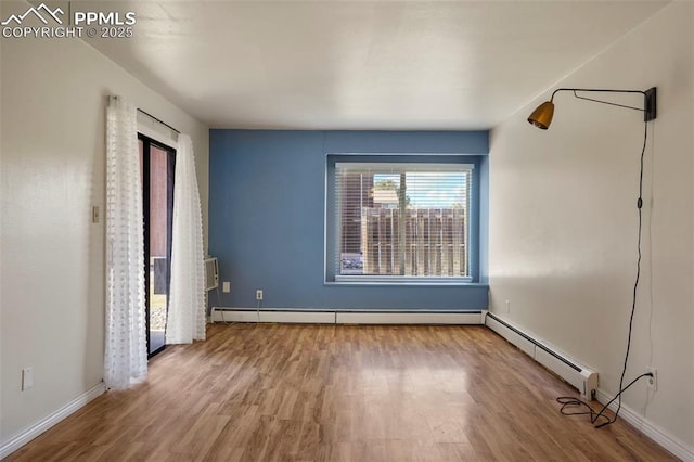 unfurnished bedroom with a baseboard radiator, wood finished floors, and baseboards