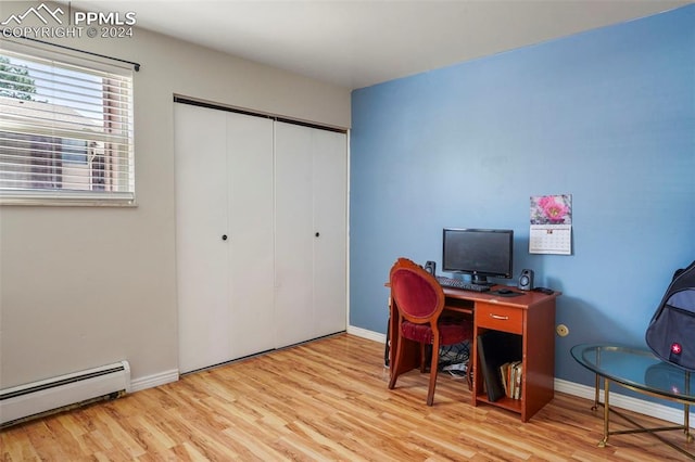 home office with light hardwood / wood-style flooring and a baseboard radiator