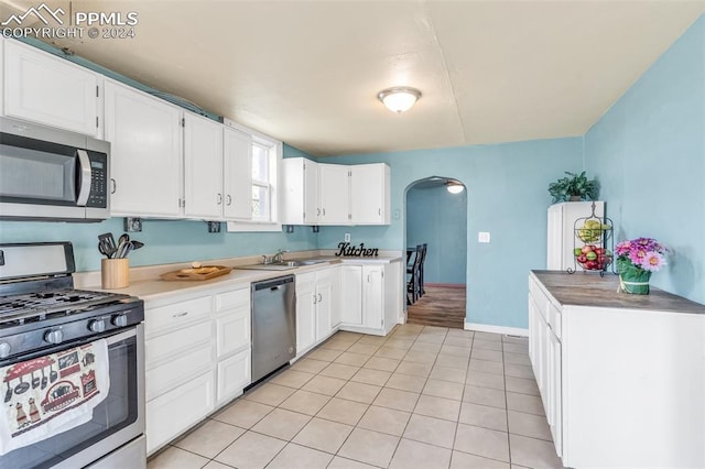 kitchen featuring white cabinetry, sink, stainless steel appliances, and light tile patterned flooring