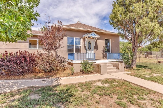 view of front of home with a porch and a front lawn