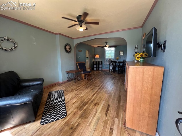 living room with ceiling fan, ornamental molding, and wood-type flooring