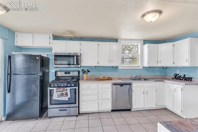 kitchen featuring white cabinetry, light tile patterned floors, sink, and appliances with stainless steel finishes