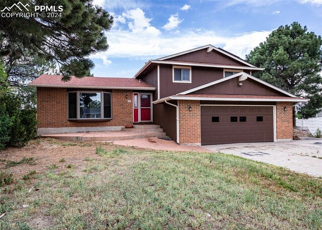 tri-level home featuring a front yard and a garage