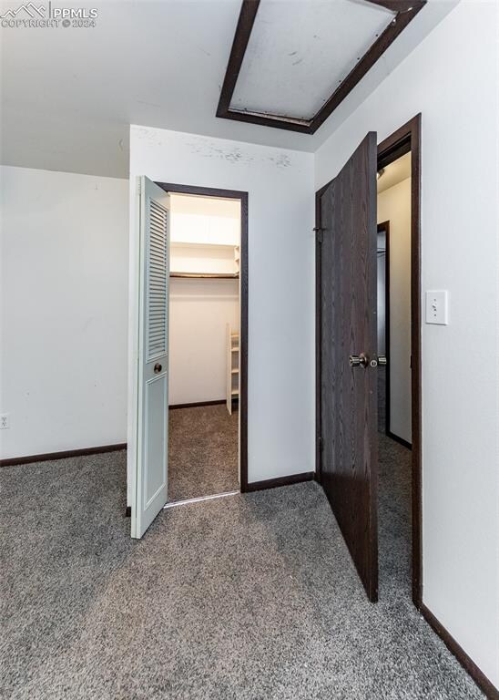 unfurnished bedroom with carpet flooring, a spacious closet, and a closet