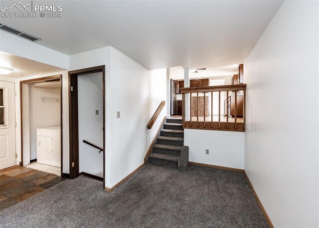 staircase featuring washer / dryer and carpet flooring