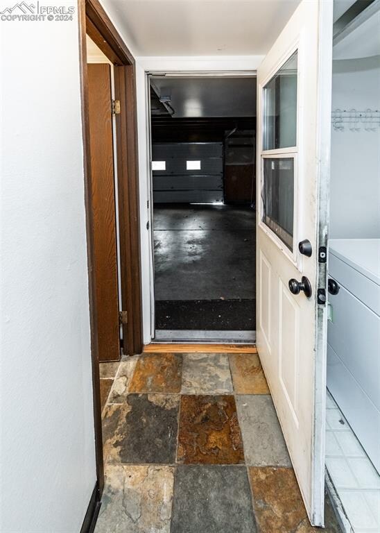 hall with tile patterned floors